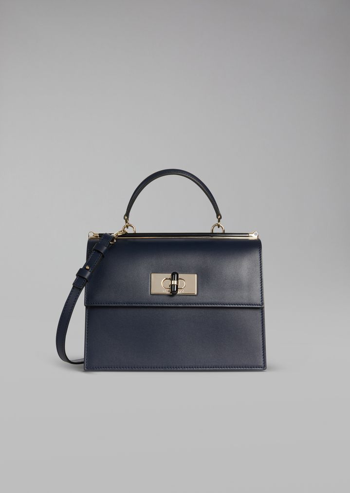 Bolso de mano de piel lisa con cierre giratorio y detalles de plexiglás Bolso de mano de piel lisa con cierre giratorio y detalles de plexiglás